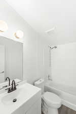 Bathroom featuring bathtub / shower combination, vanity, and wood finished floors