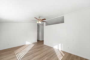 Unfurnished room featuring wood finished floors, ceiling fan, and a textured ceiling