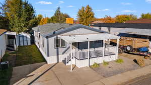 View of front of house featuring a storage shed, a metal roof, and covered porch