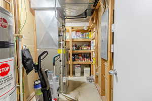 Storage room with water heater, heating unit, and electric panel
