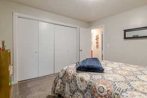 Carpeted bedroom with a closet