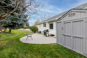 View of yard with a patio area and a storage shed