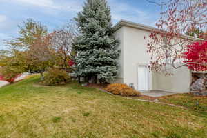 View of home's exterior featuring a yard and stucco siding