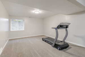 Workout room with a textured ceiling and light colored carpet