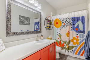Full bath with vanity, curtained shower, and dark wood finished floors
