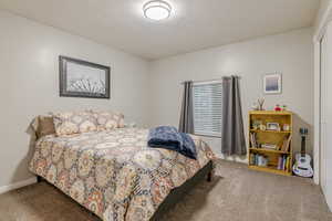 Bedroom featuring light carpet and a textured ceiling