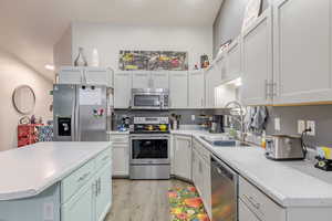 Kitchen featuring appliances with stainless steel finishes, light countertops, light wood-style floors, and recessed lighting