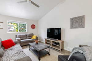 Living area featuring vaulted ceiling, wood finished floors, and ceiling fan