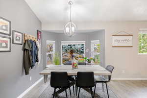 Dining area featuring light wood-style flooring and a chandelier