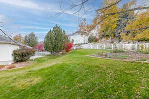 Fenced backyard featuring a garden