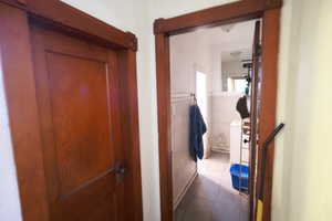 Hallway with tile walls and dark tile patterned flooring