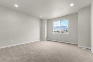 Empty room featuring a mountain view, light colored carpet, and recessed lighting