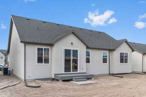 Rear view of property with roof with shingles and stucco siding