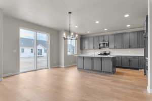 Kitchen featuring a chandelier, recessed lighting, decorative light fixtures, stainless steel appliances, and light wood-style flooring