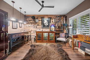 "Man Cave" wooden walls, ceiling fan, and wood finished floors