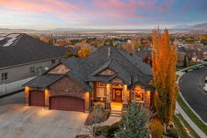 View of front of property with an attached garage, concrete driveway, a mountain view, and brick siding
