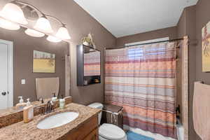 ensuite bath with vanity and shower / tub combo with curtain