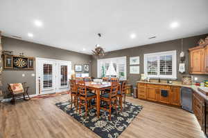 Dining space with recessed lighting, light wood-style flooring, a chandelier, and beverage cooler
