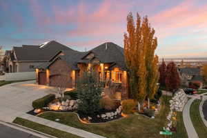 View of front of home featuring driveway, brick siding, a garage, and a lawn