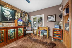 "Man Cave" with wood finished floors and baseboards