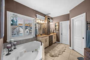 Primary Full bath with double vanity, a whirlpool tub, and light tile patterned flooring
