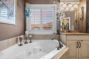 Primary Full bath with a whirlpool tub and vanity