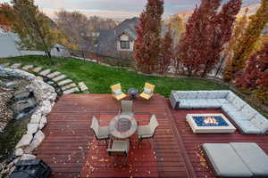 Wooden terrace with an outdoor fire pit and a fenced backyard