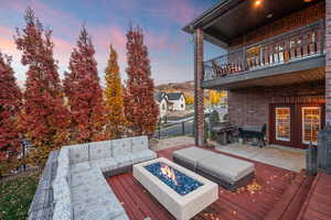 Wooden deck featuring a fire pit, french doors, area for grilling, and a patio area