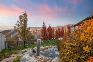 Fenced backyard with a small pond and a mountain view