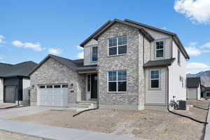 View of front of house with concrete driveway, an attached garage, brick siding, and a mountain view