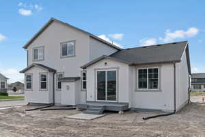 Rear view of property featuring stucco siding and roof with shingles