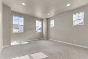 Unfurnished room with light carpet, recessed lighting, and healthy amount of natural light