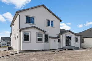 Back of property with stucco siding and entry steps