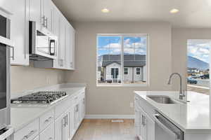 Kitchen with white cabinets, light wood-type flooring, and recessed lighting