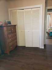 Bedroom featuring a closet and dark wood-type flooring