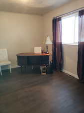Home office featuring dark wood-style flooring and ornamental molding