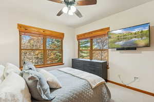 Carpeted bedroom with baseboards and a ceiling fan