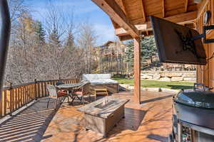 Deck with grilling area, outdoor dining area, and an outdoor fire pit