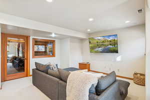 Carpeted living room with recessed lighting and baseboards