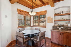 Dining room featuring a wood ceiling with exposed beams and dark wood-type flooring