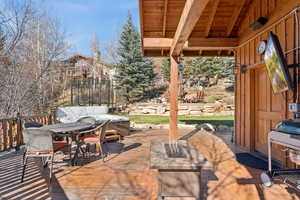 View of patio / terrace with outdoor dining space, a fire pit, and a deck