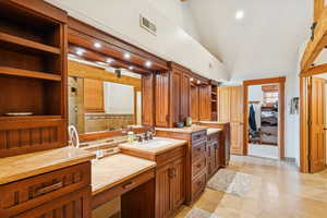 Full bathroom featuring vanity, a spacious closet, recessed lighting, and high vaulted ceiling
