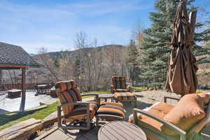 View of patio / terrace with a mountain view, an outdoor fire pit, a gazebo, and a trampoline