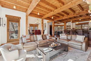 Living area featuring a wooden ceiling with exposed beams, wood finished floors, and a chandelier