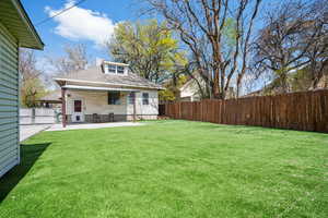 Rear view of house featuring roof with shingles, a patio, and a fenced backyard