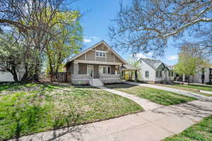 View of front of house with covered porch, a carport, stucco siding, and driveway