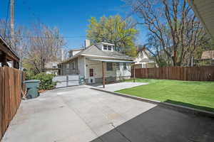 Rear view of property with a fenced backyard, a chimney, a gate, and a shingled roof