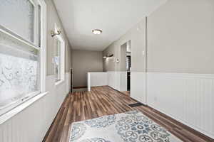 Hallway with dark wood finished floors and wainscoting