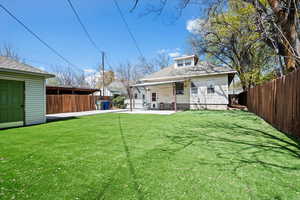 Rear view of house featuring roof with shingles, a patio, and a fenced backyard