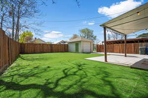 Fenced backyard with an outbuilding and a patio